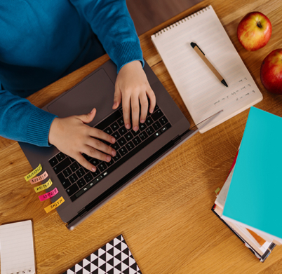 A Preteen boy uses a laptop to make online classes, top view , hands typing